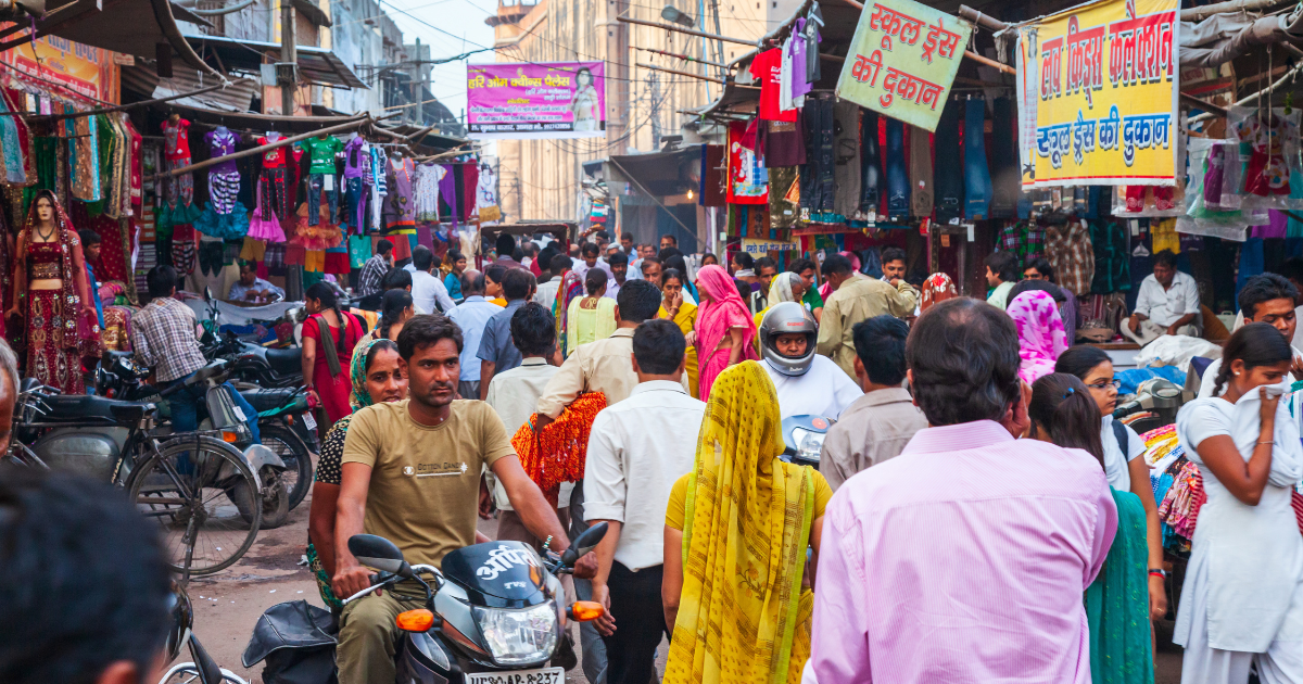 Picture of a crowded street market in India. Over 80% of the population resides in districts susceptible to natural disasters.